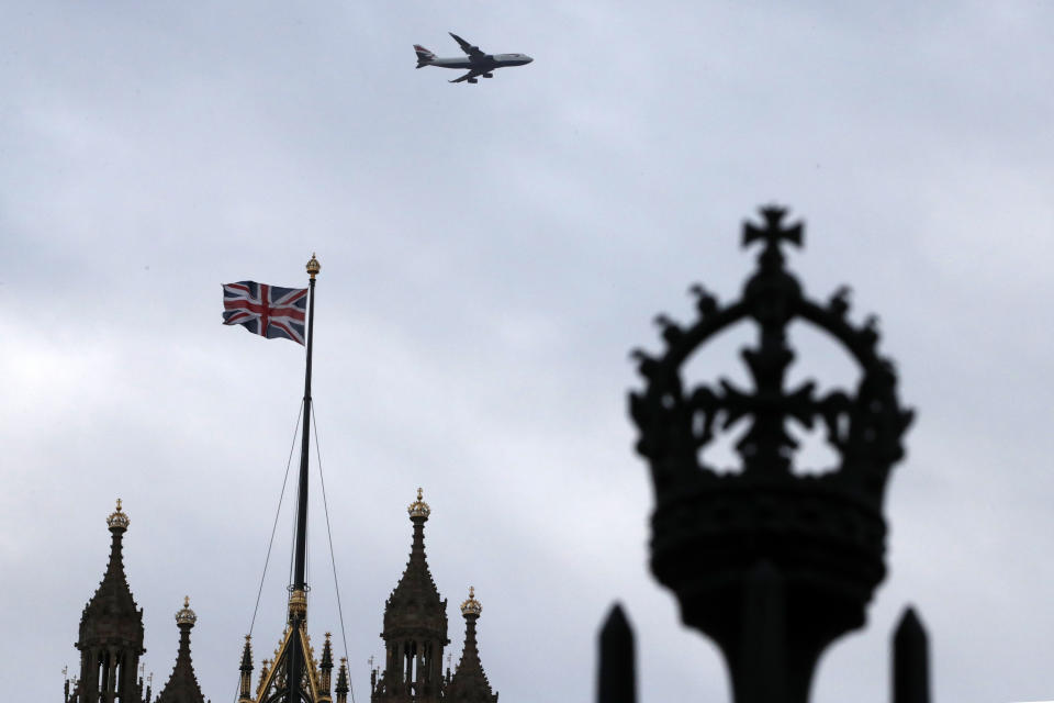 FILE - In this file photo dated Saturday, Dec. 14, 2019, a British flag waves atop of Houses of Parliament as an aircraft approaches the airport in London. After nearly five decades of economic and social integration, from the start of 2021 Britain will embark on a more-distant relationship with the European Union, and freedom of movement seems set to dramatically change for people wanting to cross the English Channel. (AP Photo/Thanassis Stavrakis, FILE)