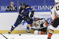 Anaheim Ducks' Jakob Silfverberg (33) falls to the ice as he works against St. Louis Blues' David Perron (57) for the puck during the second period of an NHL hockey game Friday, March 26, 2021, in St. Louis. (AP Photo/Joe Puetz)