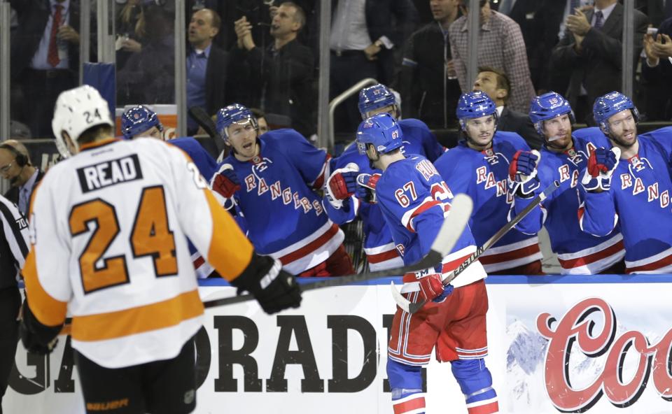 Philadelphia Flyers right wing Matt Read (24) skates away as New York Rangers' Benoit Pouliot (67) celebrates with teammates after scoring a goal during the second period in Game 7 of an NHL hockey first-round playoff series on Wednesday, April 30, 2014, in New York. (AP Photo)