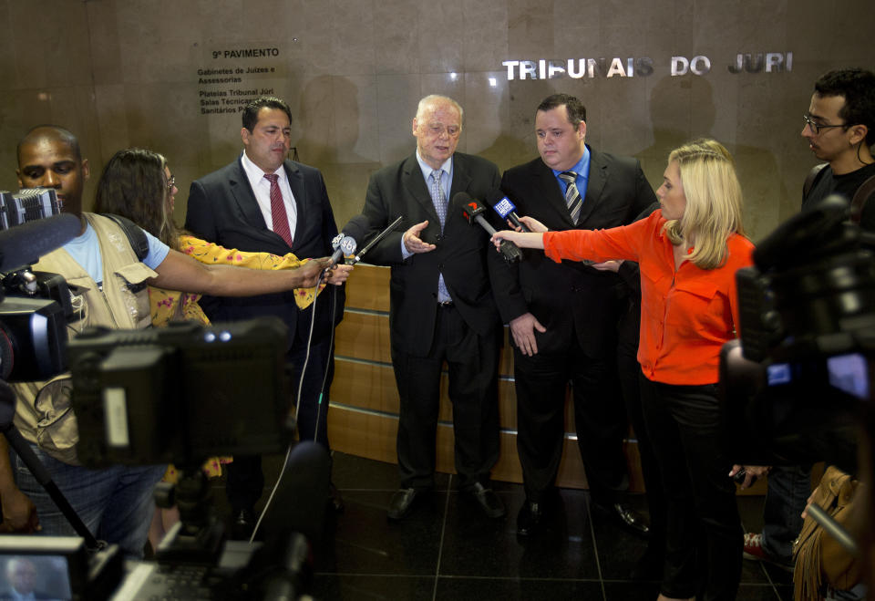 Eduardo Mayr, center, speaks to journalists, as he's flanked by fellow lawyers Mauricio Eduardo Mayr, right, and Anderson Rollenberg, all of whom represent Mario Marcelo Ferreira dos Santos Santoro in Rio de Janeiro, Brazil, Wednesday, Sept. 19, 2018. A pre-trial hearing was held in the case of the Brazilian man charged with killing his former girlfriend in Australia. (AP Photo/Silvia Izquierdo)