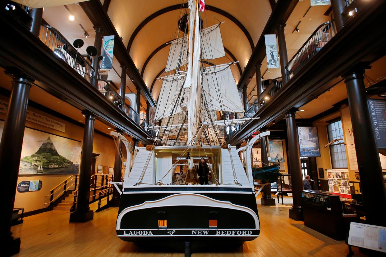 A woman peeks through the opening in the stern of the 1/2 scale whaling ship, Lagoda, inside of the New Bedford Whaling Museum.