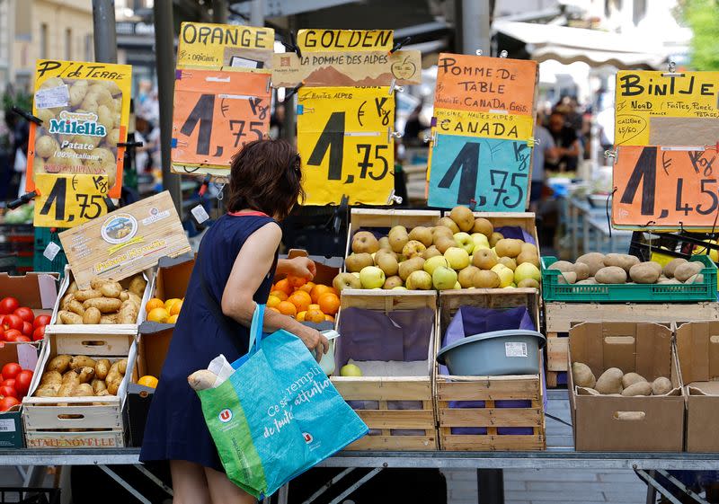 Price tags are seen as a woman shops at a local market in Nice