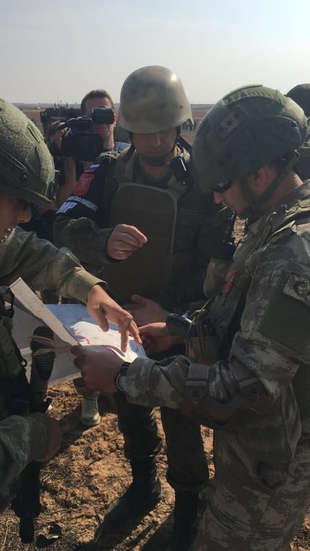 Turkish and Russian soldiers meet on the Turkish-Syrian border before a joint patrol in northeast Syria, near the Turkish town of Kiziltepe