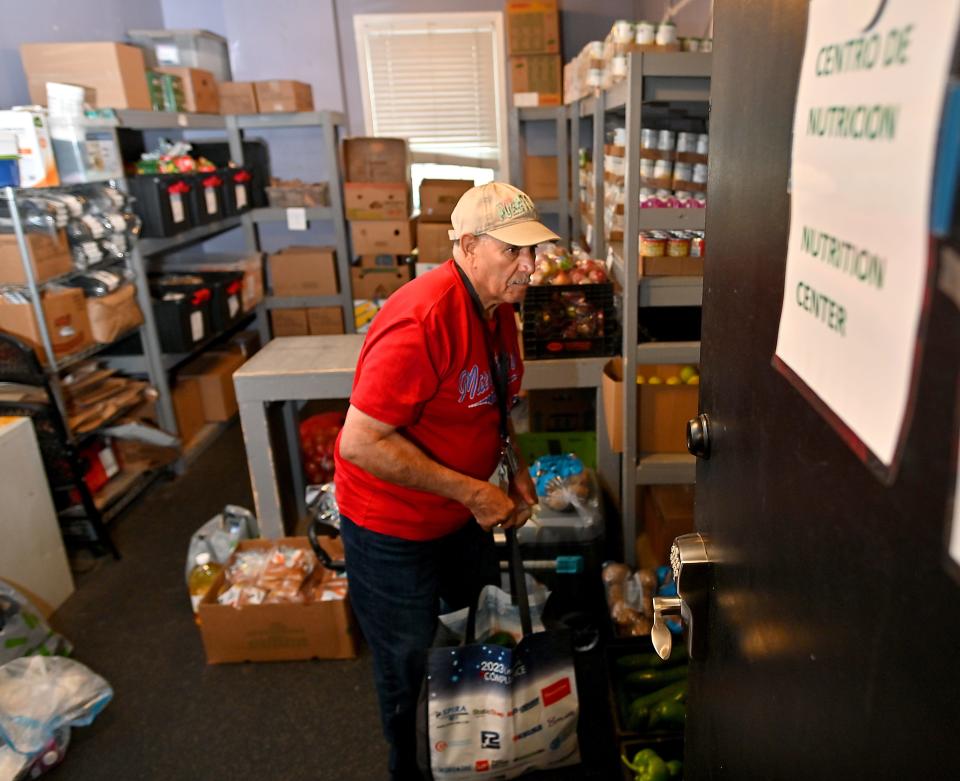Enrique Gonsalves of Worcester searches for pantry items to fill his bag at Jeremiah's Inn food pantry on Thursday.