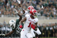 Indiana's Whop Philyor (1) returns a kick as Indiana's Taiwan Mullen, rear, illegally blocks Michigan State's Dominique Long (9) during the first quarter of an NCAA college football game, Saturday, Sept. 28, 2019, in East Lansing, Mich. (AP Photo/Al Goldis)