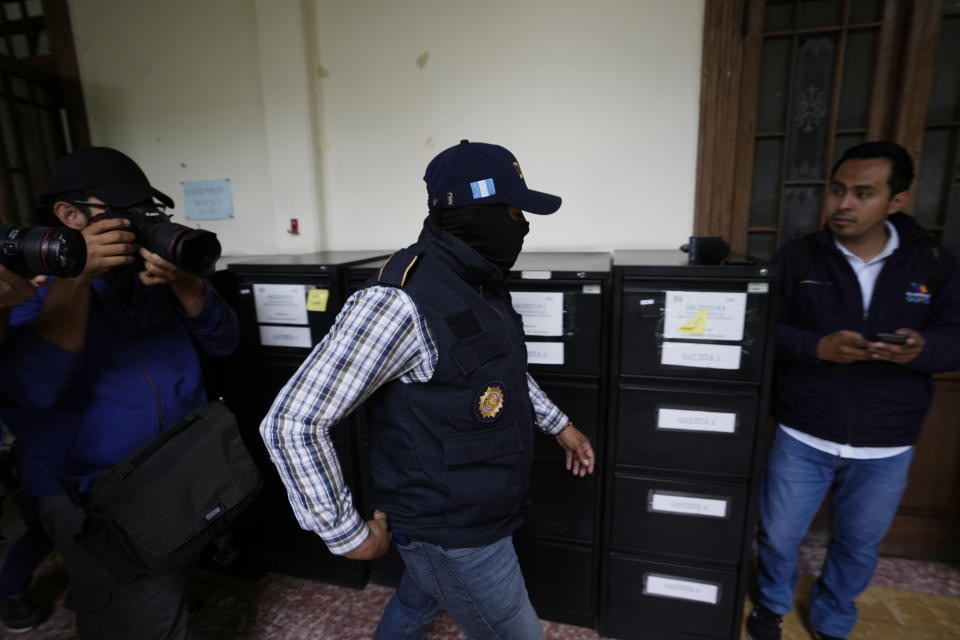 A police officer from Guatemala's attorney general's office raids the headquarters of the country's electoral authority hours after it certified the results of the country's June 25 election in Guatemala City, Thursday, July 13, 2023. The Attorney General's Office said the raid's purpose was to search and seize evidence in the offices of the citizen registry.(AP Photo/Moises Castillo)