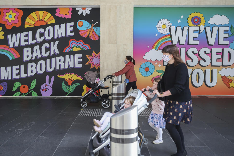 FILE - Women wearing face masks push strollers past signage in Melbourne, Australia, Wednesday, Oct. 28, 2020. On Friday, March 24, 2023 The Associated Press reported on stories circulating online incorrectly claiming Australia is seeing its sharpest rise in deaths in 80 years because of the coronavirus vaccine. (AP Photo/Asanka Brendon Ratnayake, File)