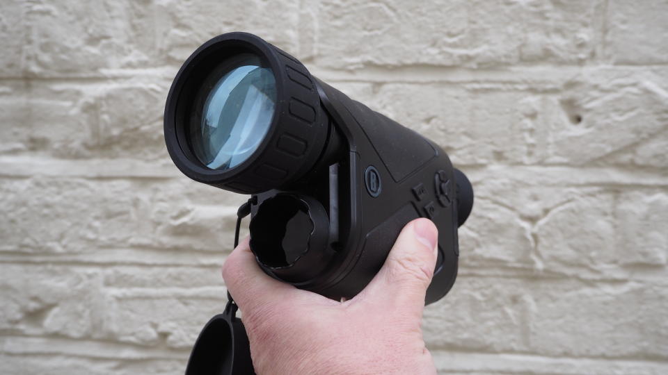 Bushnell Equinox Z2 6x50 Night Vision Monocular held in a hand against a white wall