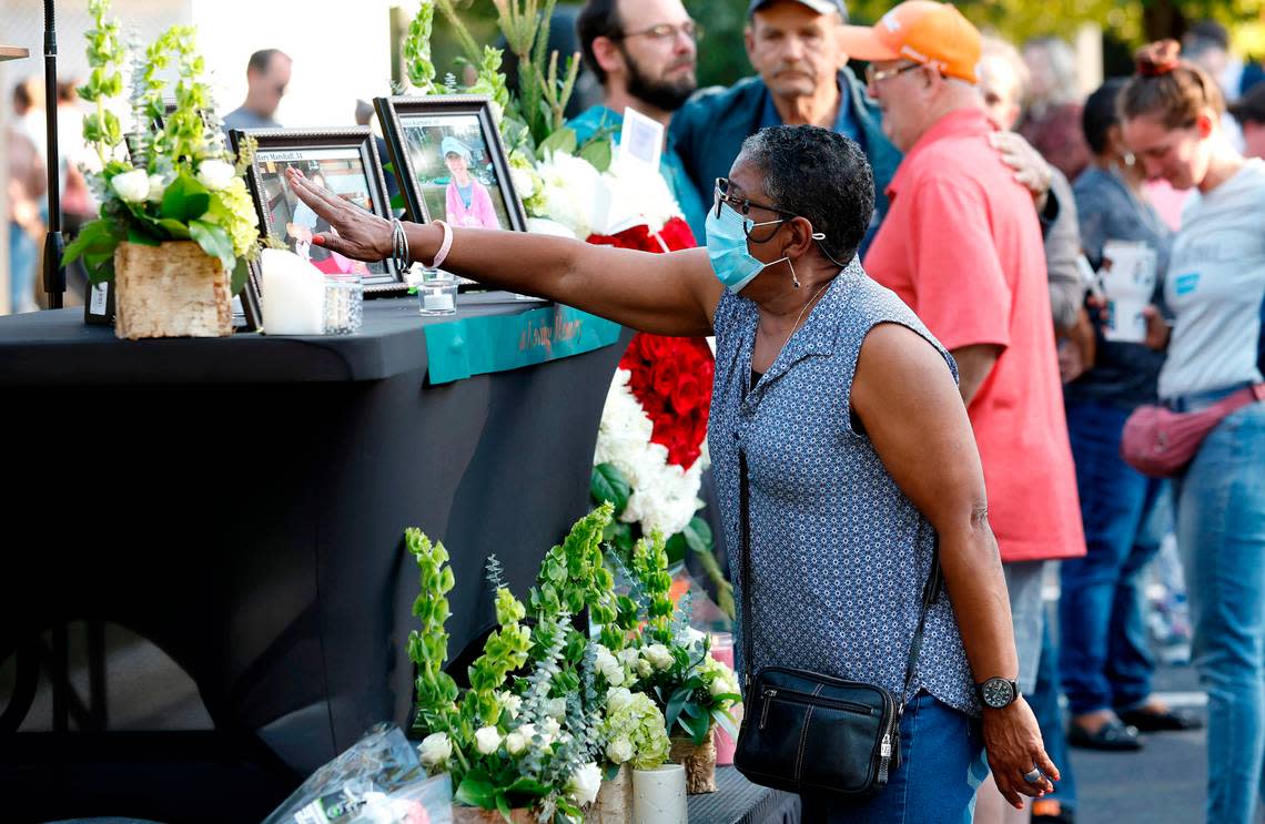 After a candlelight vigil outside the Hedingham clubhouse Saturday, Oct. 15, 2022, attendees look at a memorial for those killed and wounded in a mass shooting in the Hedingham neighborhood in Raleigh, N.C., on Thursday.