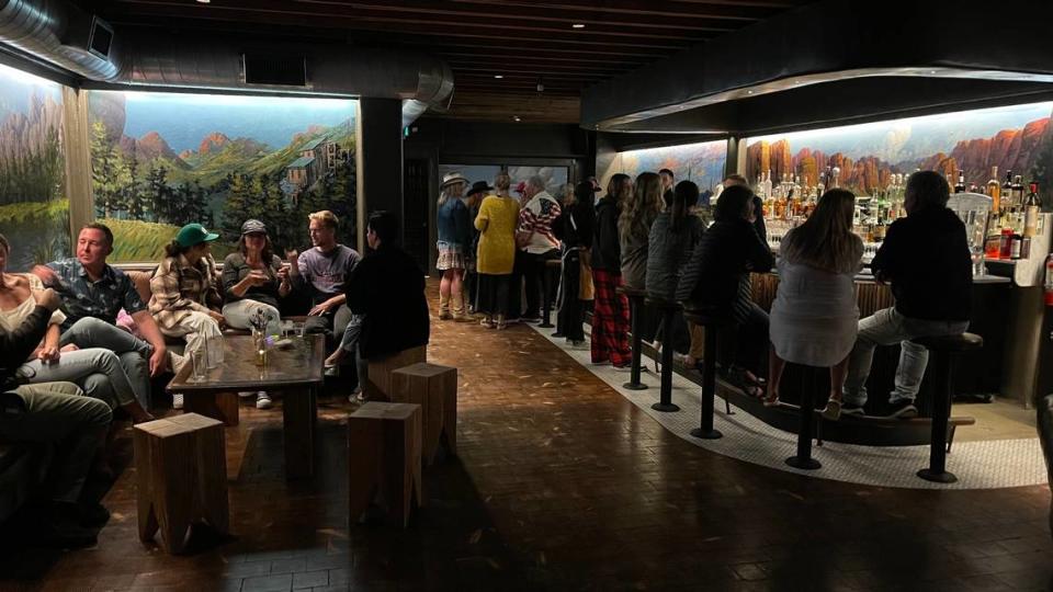 Patrons drink and dine at Club Car Bar during a soft opening event. The picture also features the original, hand-painted murals by local artist Hugh Slayden.