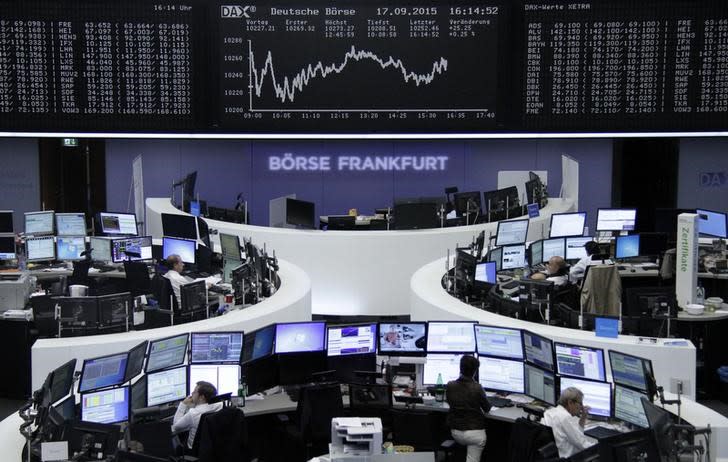 Traders are pictured at their desks in front of the DAX board at the stock exchange in Frankfurt, Germany, September 17, 2015. REUTERS/Staff/remote