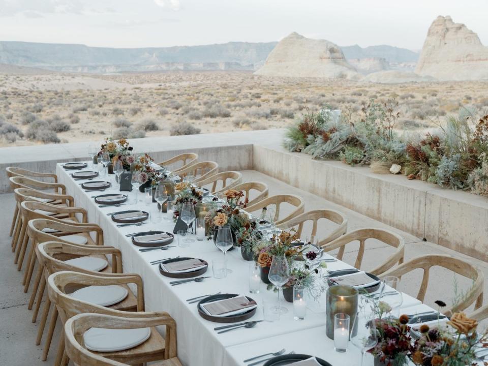 A table set for dinner with flowers overlooking a desert.