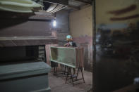 A man builds coffins at the La Amistad funeral home in Managua, Nicaragua, Wednesday, May 27, 2020. President Daniel Ortega's government has stood out for its refusal to impose measures to halt the coronavirus since the disease was first diagnosed in Nicaragua. Now, doctors and family members of apparent victims say, the government has gone from denying the disease's presence in the country to actively trying to conceal its spread. (AP Photo/Alfredo Zuniga)