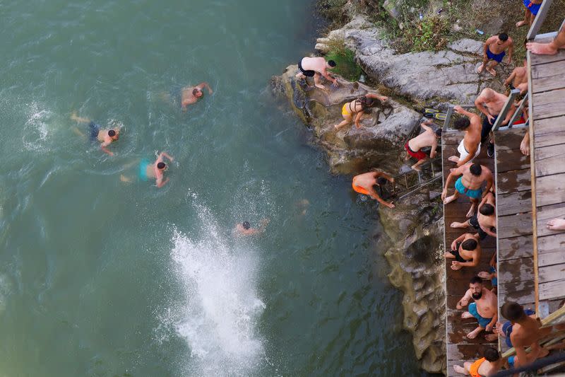 Divers jump into a river from a bridge in Kosovo