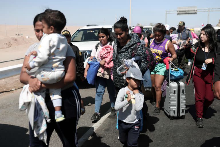 Migrantes que salen de Chile, en las oficinas migratorias de Tacna. (ALDAIR MEJIA / AFP)