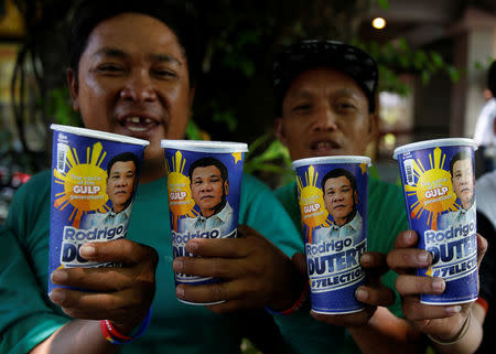 Mall parking attendants and supporters of presidential candidate Rodrigo Duterte for the May 9 election, pose with "Big Gulp" soda cups they bought from convenience store 7-Eleven, in Paranaque, Metro Manila, Philippines April 25, 2016. REUTERS/Erik De Castro