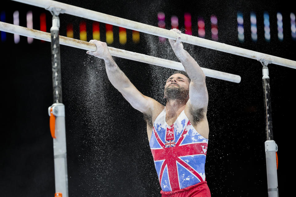 Great Britain's James Hall uses chalk before competing on the parallel bars during the Men's team final at the Artistic Gymnastics World Championships in Antwerp, Belgium, Tuesday, Oct. 3, 2023. (AP Photo/Geert Vanden Wijngaert)