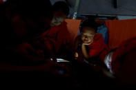 Boys play with their mobile phones and tablets at Wat Klang Thung temple where they temporarily live after entering Buddhist novicehood, in Mae Hong Son, Thailand, April 15, 2018. REUTERS/Jorge Silva