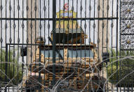 Barbed wire and a military armored personnel carrier block a side entrance of the Tunisian parliament in Tunis, Tuesday, July 27, 2021. The Ennahda party, has called for dialogue, following President Kais Saeid's sacking of the prime minister and suspension of parliament on Sunday. (AP Photo/Hassene Dridi)