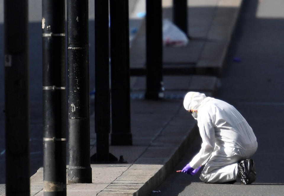 A police forensics investigator works on London Bridge.