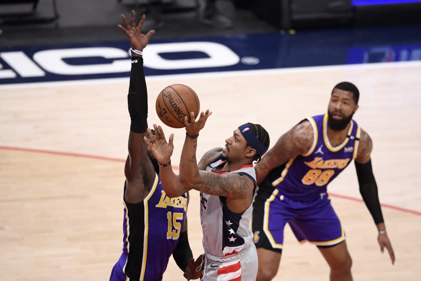 Washington Wizards guard Bradley Beal (3) goes to the basket against Los Angeles Lakers center Montrezl Harrell (15) and forward Markieff Morris (88) during the first half of an NBA basketball game, Wednesday, April 28, 2021, in Washington. (AP Photo/Nick Wass)