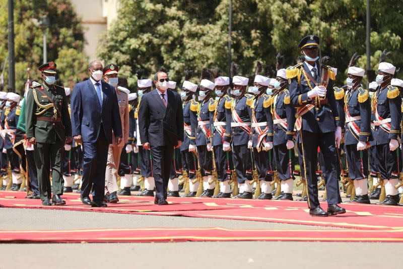 Sudan's Sovereign Council Chief General Abdel Fattah al-Burhan walks with Egyptian President Abdel Fatah al-Sisi, during a welcome ceremony in Khartoum