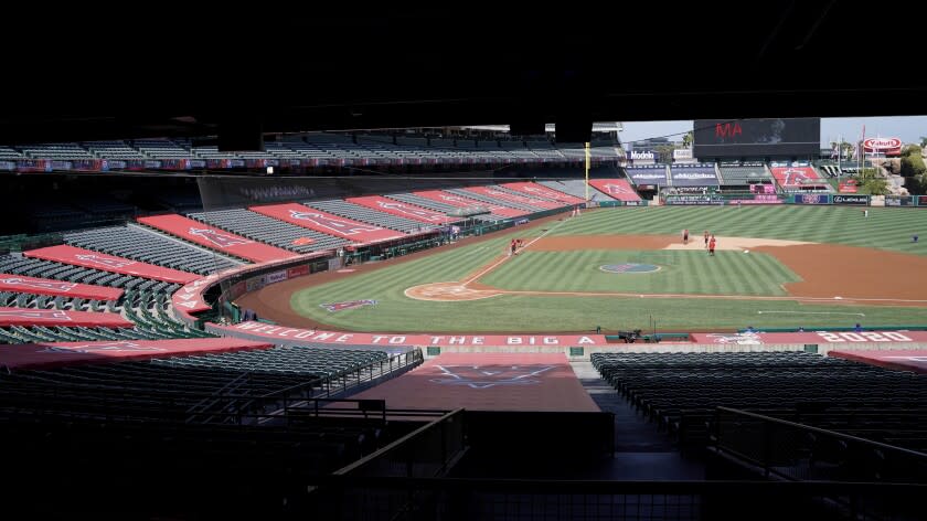 Grounds crew work to prepare Angel Stadium for a baseball game between the Los Angeles Angels.
