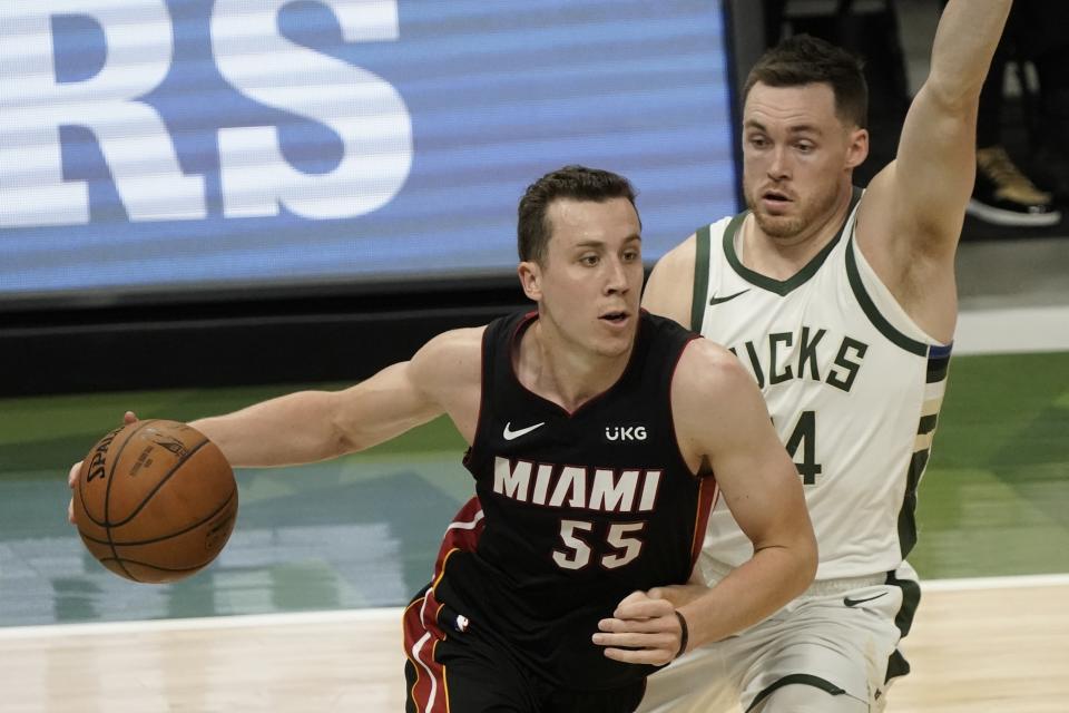 Miami Heat's Duncan Robinson drives past Milwaukee Bucks' Pat Connaughton during the first half of an NBA basketball game Saturday, May 15, 2021, in Milwaukee. (AP Photo/Morry Gash)