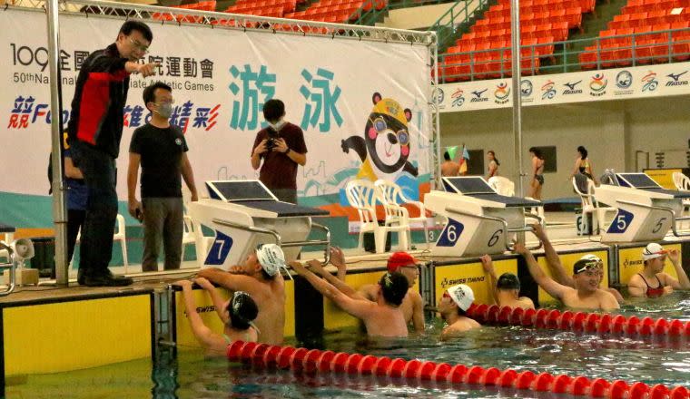 運動發展局局長侯尊堯（左1）於國際游泳池畔為全大運參賽選手加油。高雄市政府運動發展局提供