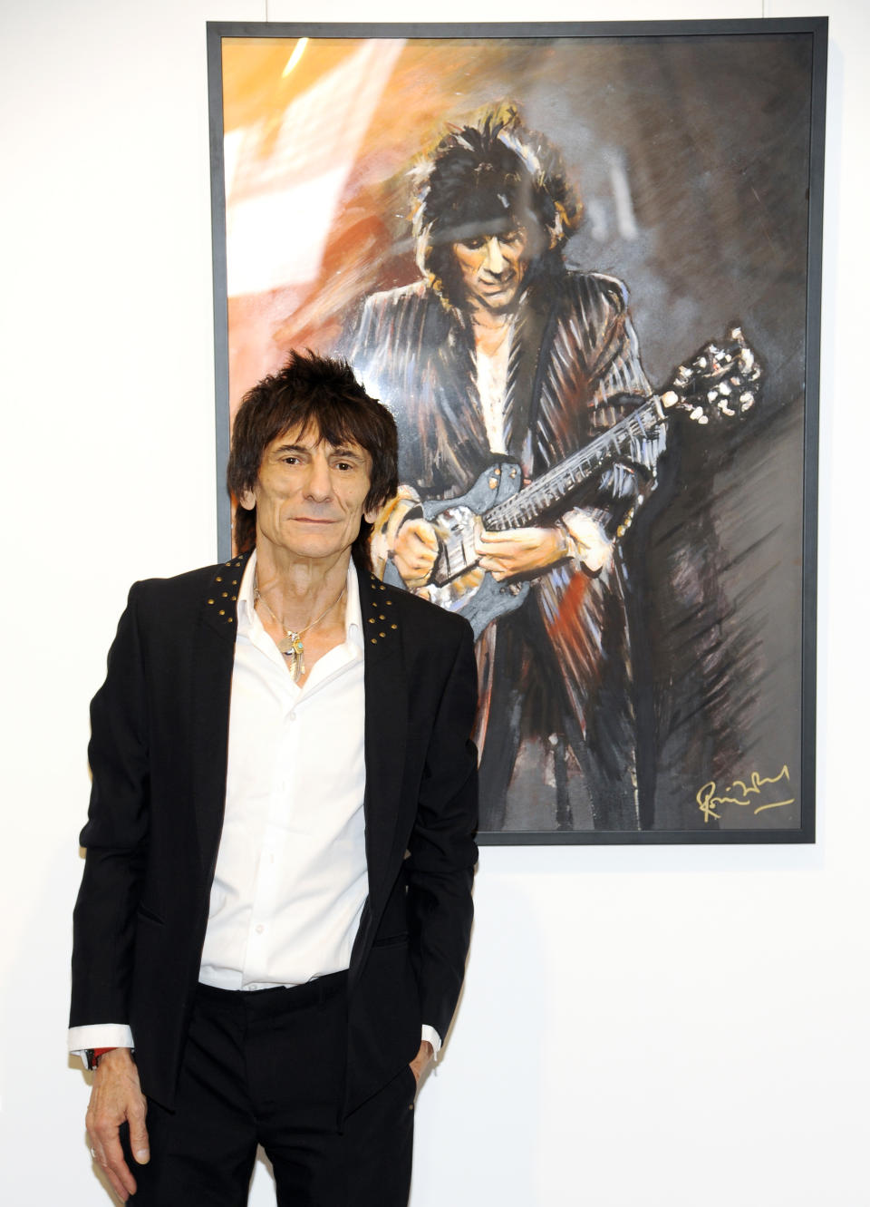 Rolling Stones guitarist Ronnie Wood stands near one of his pieces during a news conference unveiling his new art exhibit "Faces, Time and Places" on Monday, April 9, 2012, in New York. (AP Photo/Evan Agostini)