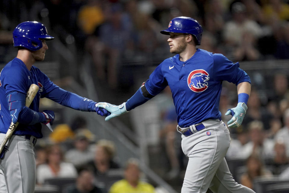 Chicago Cubs' Ian Happ, right, celebrates after his home run against the Pittsburgh Pirates with Cody Bollinger, left, in the ninth inning of a baseball game in Pittsburgh, Friday, Aug. 25, 2023. (AP Photo/Matt Freed)