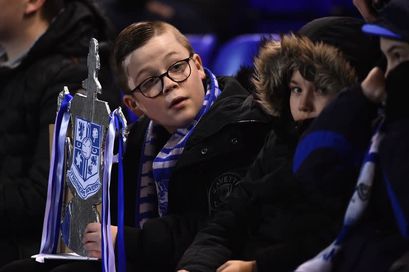 A young Tranmere Rovers fan with a tin-foil FA Cup ahead of their FA Cup replay against Watford in 2020.