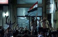 Egyptian protesters gather on a street near the US Consulate as US Secretary of State Hillary Clinton attends a flag-raising ceremony at the Consulate General in the mediterranean city of Alexandria. Clinton met Sunday with Egypt's top military leaders, urging them to support a transition to civilian rule as a political struggle triggers fears that rights could be eroded