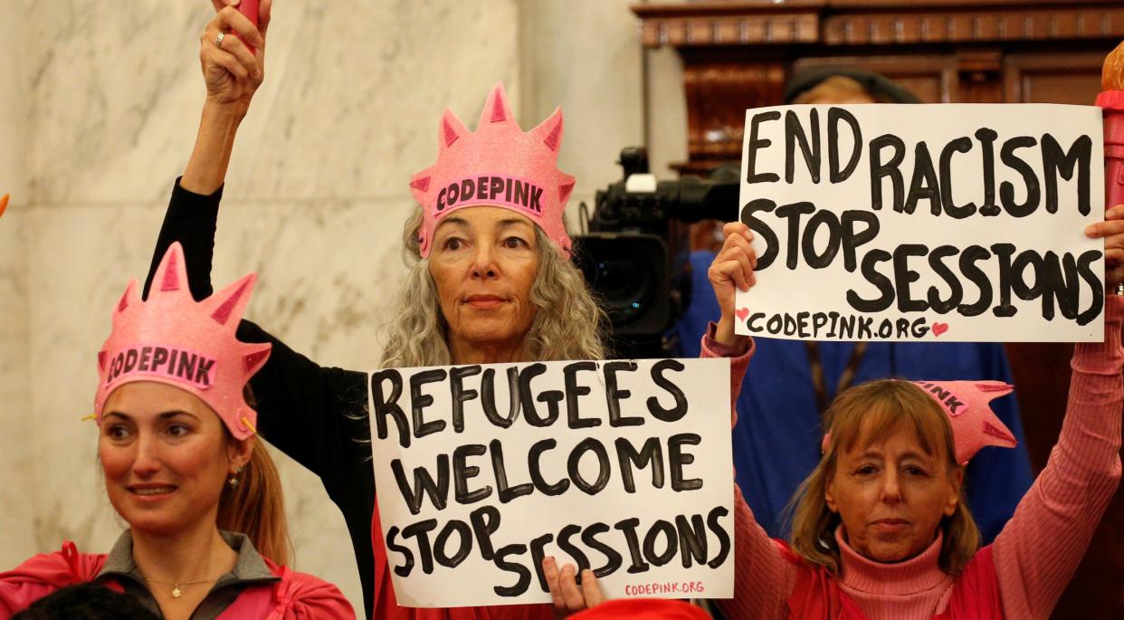 Protesters hold signs at the Senate Judiciary Committee confirmation hearing for Jeff Sessions to become U.S. attorney general on Jan. 10, 2017. (Photo: Kevin Lamarque/Reuters)