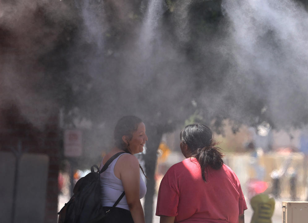 PHOENIX, ARIZONA - JUNE 05: People cool off under a mister on June 05, 2024 in Phoenix, Arizona. According to the National Weather Service, Phoenix will experience record temperatures over 100 degrees as a pattern of high pressure builds over the region. A forecasted high of 114 is expected on Thursday. (Photo by Justin Sullivan/Getty Images)