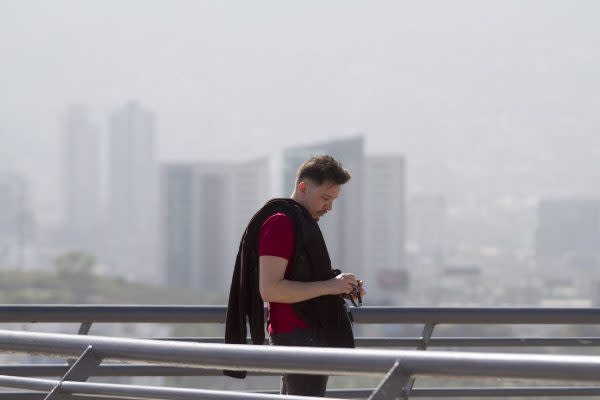 persona en monterrey y de fondo la ciudad con contaminación en el aire