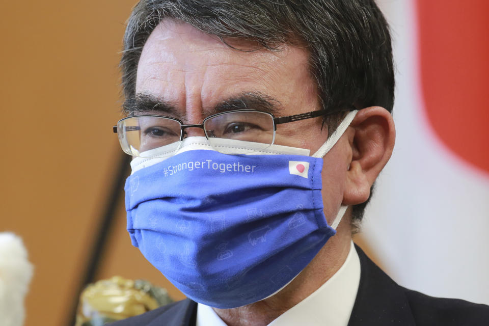Japanese Vaccine Minister Taro Kono wearing a face mask with flags of Japan and EU, left, on it speaks during an interview in Tokyo, Monday, March 29, 2021. Kono tasked with COVID-19 vaccinations urged the EU to ensure stable shipment of Pfizer vaccines amid distribution uncertainty in a country where the Olympics are coming up in four months. (AP Photo/Koji Sasahara)