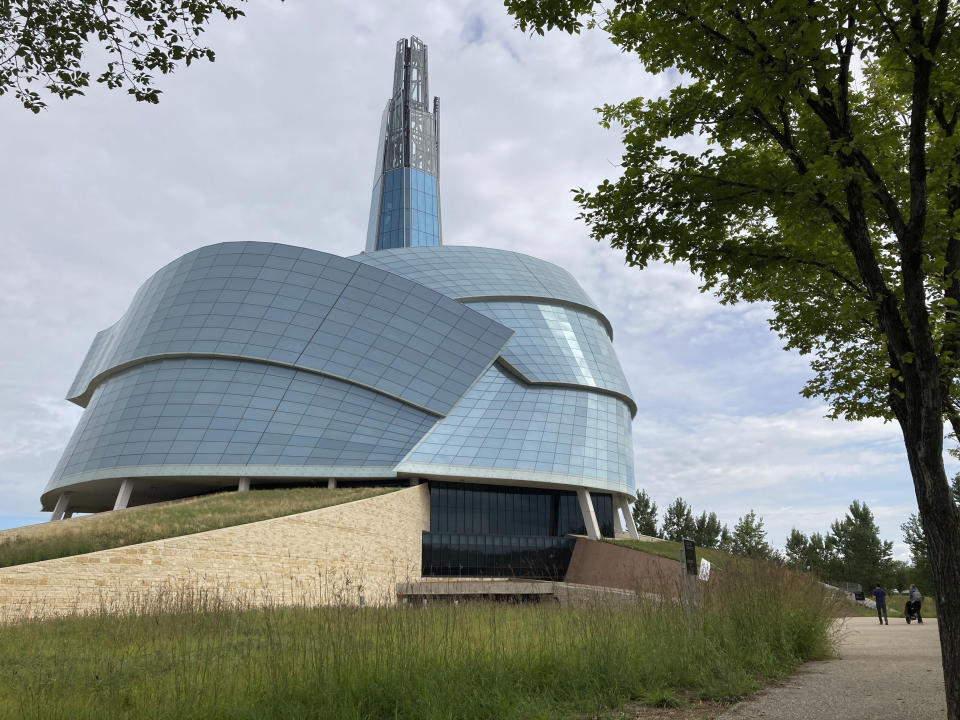 People walk by the Canadian Museum for Human Rights, created by internationally renowned architect Antoine Predock on Aug. 13, 2023, in Winnipeg, Manitoba. Predock, whose list of credits includes award-winning buildings around the world, died Saturday, March 2, 2024, at his home in Albuquerque, according to longtime friends and colleagues. He was 87. (AP Photo/Felicia Fonseca)