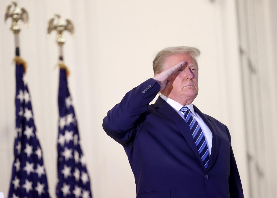 U.S. President Donald Trump salutes Marine One helicopter pilots after returning to the White House from Walter Reed National Military Medical Center on October 05, 2020 in Washington, DC. Trump spent three days hospitalized for coronavirus. (Win McNamee/Getty Images)