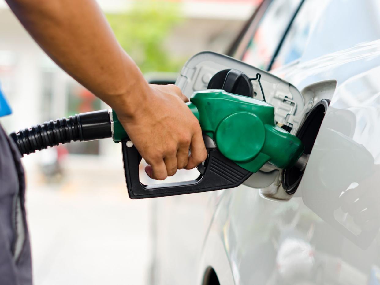 Refueling Car With Gasoline Pump Nozzle, Selective Focus on pump nozzle