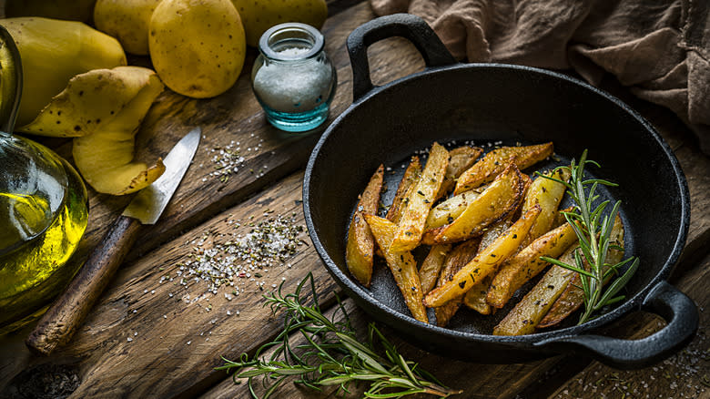 Sliced potatoes in skillet with herbs