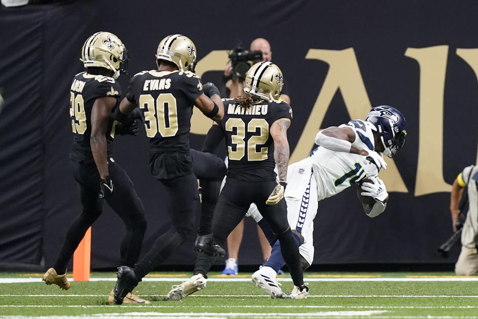 Seattle Seahawks wide receiver DK Metcalf, right, falls in the end zone for a touchdown off a pass from Geno Smith during an NFL football game against the New Orleans Saints in New Orleans, Sunday, Oct. 9, 2022. (AP Photo/Gerald Herbert)