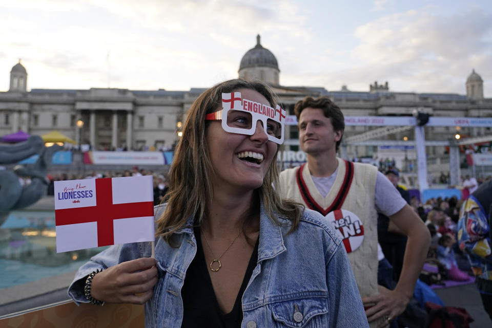 FILE - An England supporter smiles as she watches a live screening of the Women's Euro 2022 semifinal soccer match between England and Sweden at the fan area in Trafalgar Square in London, England, Tuesday, July 26, 2022. (AP Photo/Albert Pezzali, File)