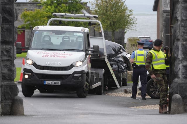 A car wrapped in plastic is removed from the scene at Renmore Barracks in County Galway