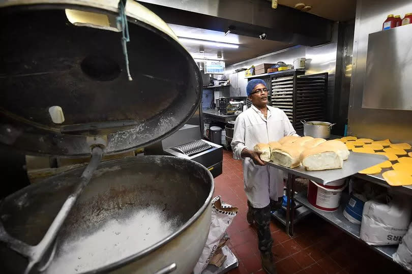 Head baker Paul Thompson by the vintage German mixer that's nearly 100 years old -Credit:Sean Hansford | Manchester Evening News