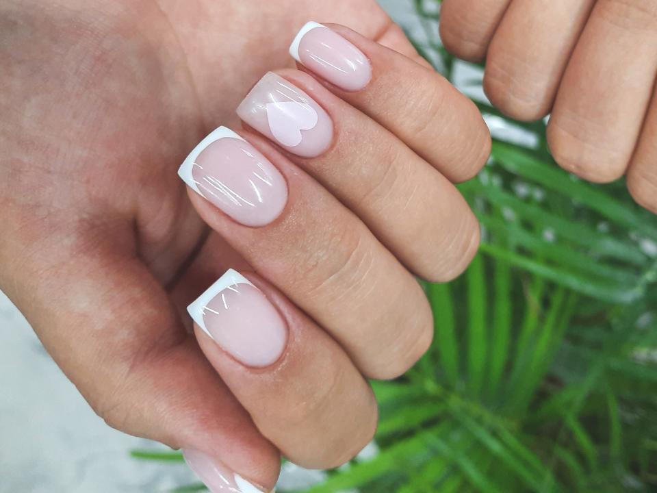 woman with cute square duck nail french manicure with hearts and hello kitty