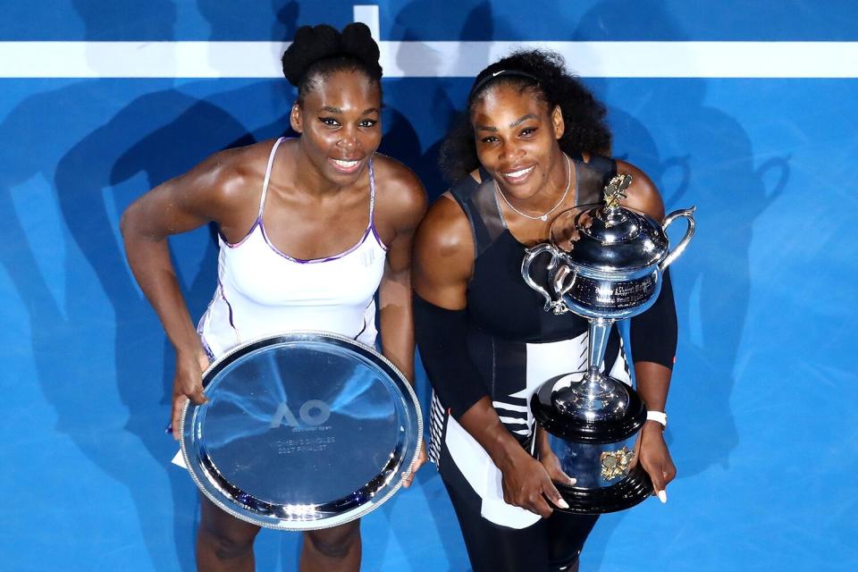 Serena Williams of the United States poses with the Daphne Akhurst Trophy alongside Venus Williams of the United States, posing with the runners up plate after the Women's Singles Final on day 13 of the 2017 Australian Open