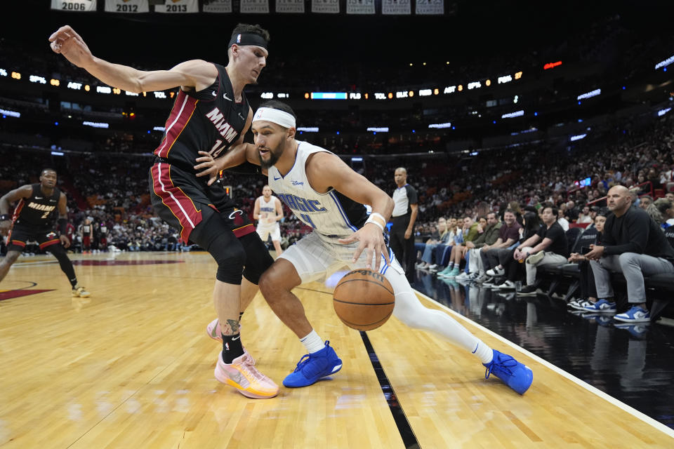 Miami Heat guard Tyler Herro (14) defends as Orlando Magic guard Jalen Suggs (4) drives during the first half of an NBA basketball game Tuesday, Feb. 6, 2024, in Miami. (AP Photo/Rebecca Blackwell)