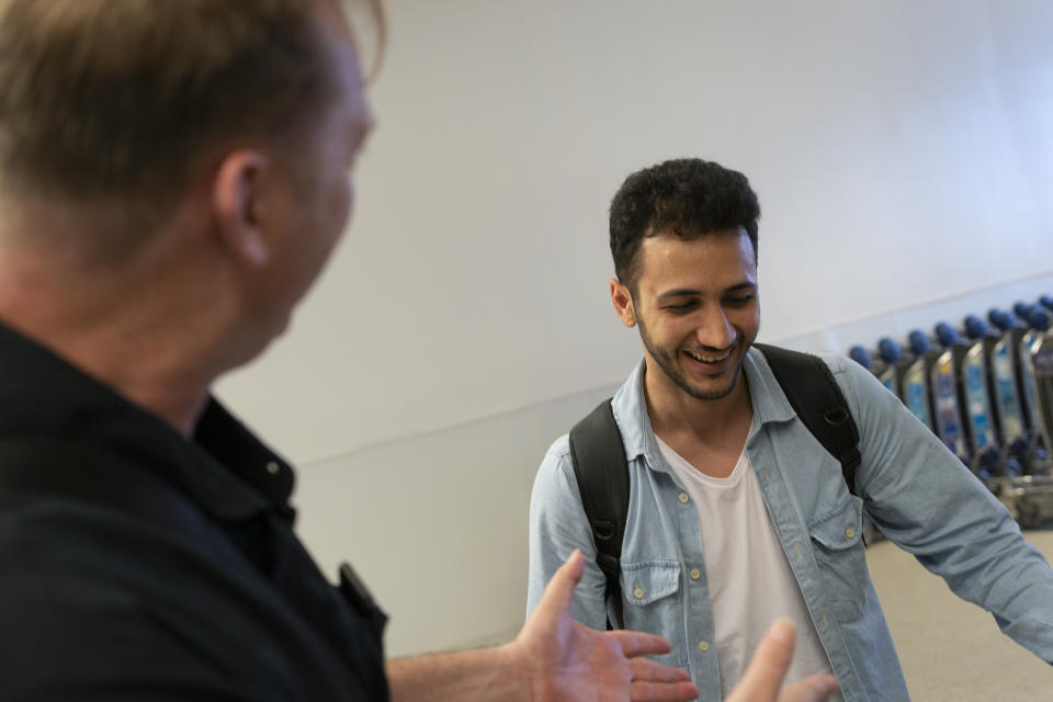 Michael White, a Navy veteran who was jailed in Iran for several years on spying charges, left, shares a light moment with Michael's former fellow prisoner and Iranian political activist Mahdi Vatankhah at the Los Angeles International Airport in Los Angeles, Thursday, June 1, 2023. Vatankhah, while in custody and after his release, helped White by providing White's mother with crucial, firsthand accounts about her son's status in prison and by passing along letters White had written while he was locked up. Once freed, White did not forget. He pushed successfully this year for Vatankhah's admission to the United States, allowing the men to be reunited last spring, something neither could have envisioned when they first met in prison years earlier. (AP Photo/Jae C. Hong)