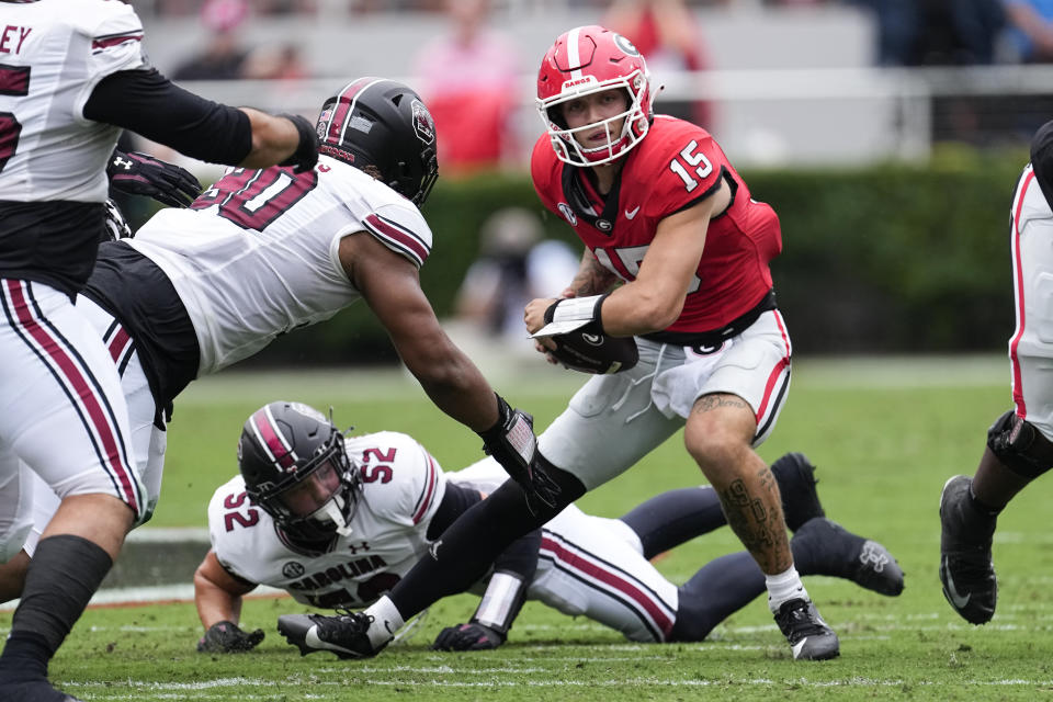 Georgia quarterback Carson Beck (15) is tackled by South Carolina defenders Stone Blanton (52) and Jace Blackshear (30) during the first half of an NCAA college football game Saturday, Sept. 16, 2023, Ga. (AP Photo/John Bazemore)